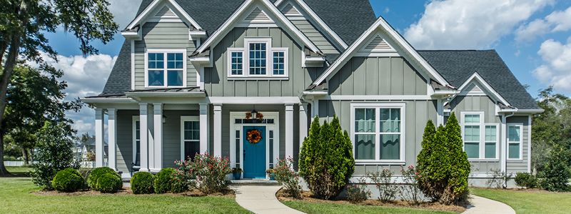 grey colonial style home with white pillars