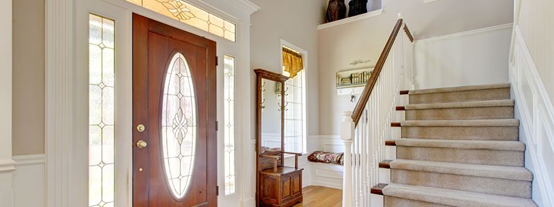 entryway of home with stair leading up and many ways for natural light to enter the area