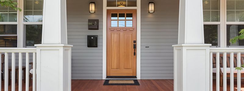 patio with pillar and railing framing front door of home